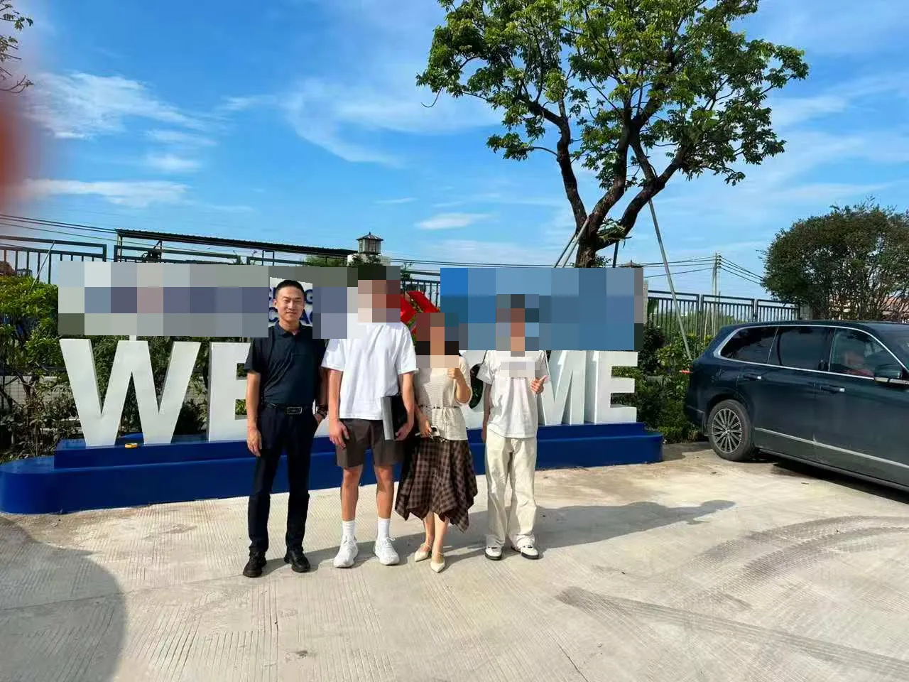 Adrian Liu at a facility; company signage and other faces redacted.